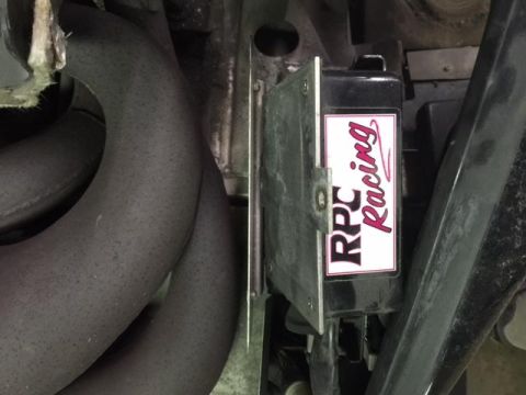 2000 Ford E350 - Close-up of exhaust pipes and an RPC Racing component, likely from a vehicle's engine bay.