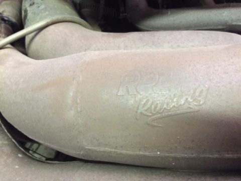 2000 Ford E350 - Close-up of an exhaust pipe with a K&N Racing logo, indicating aftermarket modification.