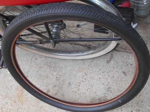 Bicycle wheel with black tire and copper rim, close-up