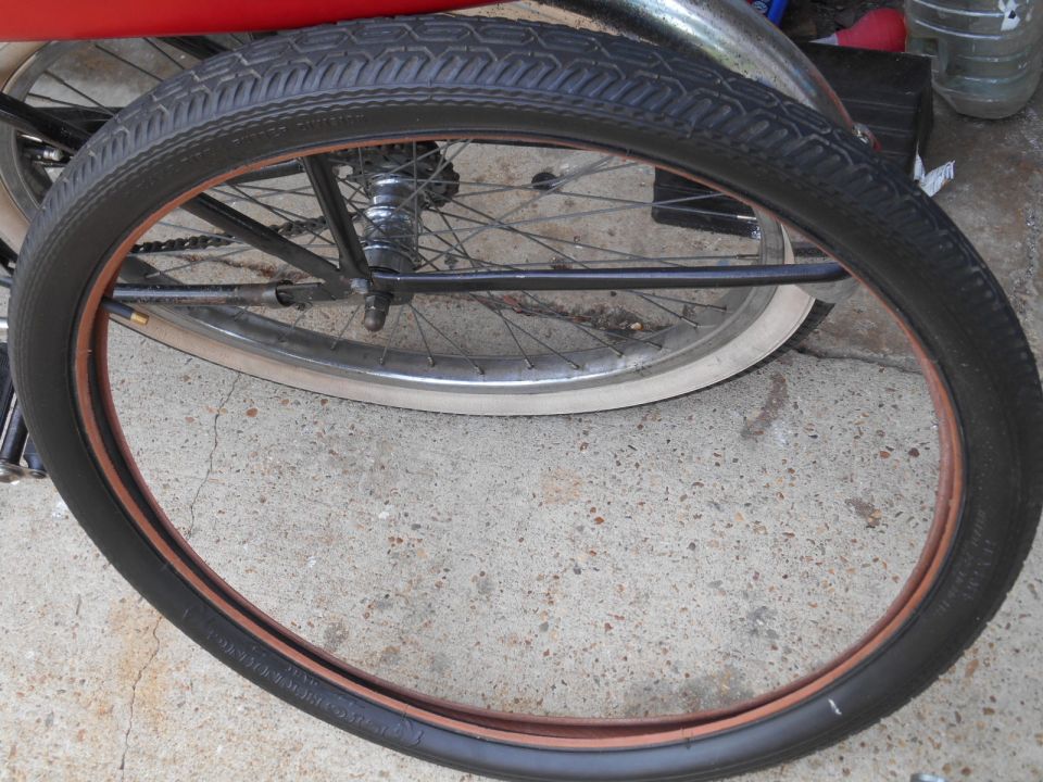 Bicycle wheel with black tire and copper rim, close-up