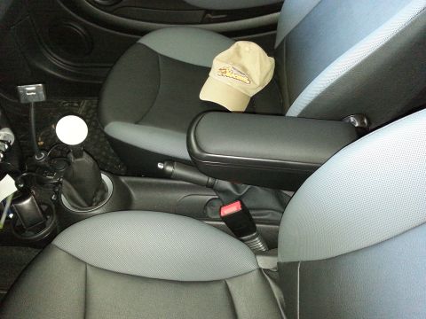 2003 Ford Crown Victoria - Interior view of a car's passenger seat and center console, a baseball cap and manual transmission shifter.