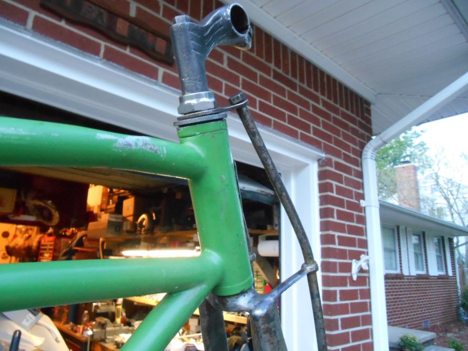 Green bicycle frame with chrome handlebars and stem, viewed from the side