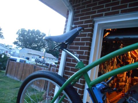 Green bicycle frame with sprung seat, close-up