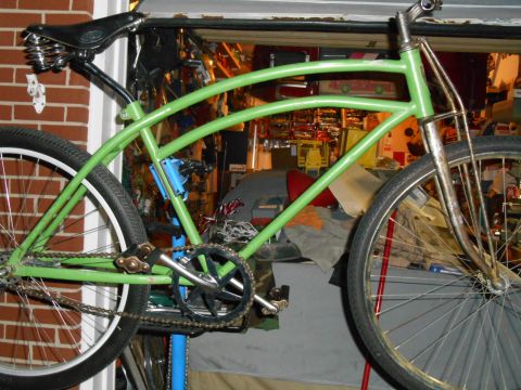 Green bicycle frame with spring saddle and chain