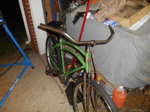 Green cruiser bicycle with chrome handlebars and fenders