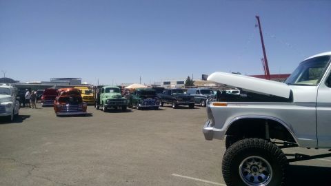 1979 Ford Bronco - A variety of vintage trucks are displayed outdoors at an event, with a lifted white truck prominently featured.