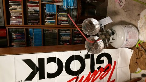 1990 Ford Bronco - A propane tank and heater are shown in front of a bookshelf, with a banner partially visible.