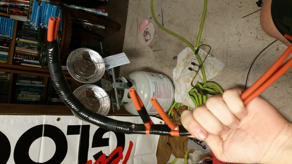 Black corrugated tubing with orange vacuum lines, propane tank, and Supermotors logo