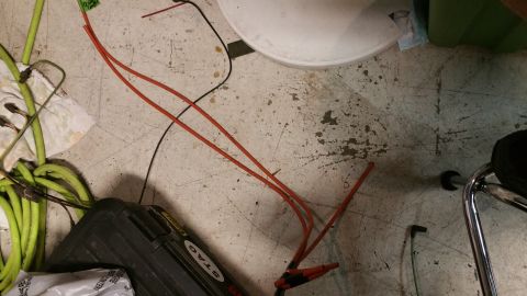 1990 Ford Bronco - Various automotive parts and tools are laid out on a garage floor.