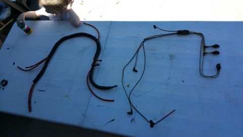 1990 Ford Bronco - Two sections of a vehicle wiring harness are displayed on a table, possibly for repair or replacement.