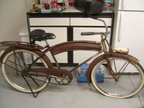 old brown bicycle with white-wall tires, black seat, and a headlight