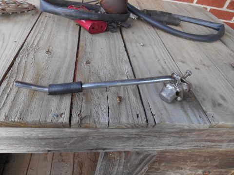 metal lever with rubber grip and clamp assembly on wooden surface