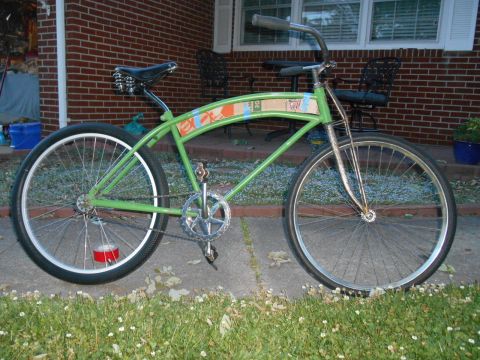 Lime green cruiser bicycle with red duct tape on rear wheel, parked on sidewalk.