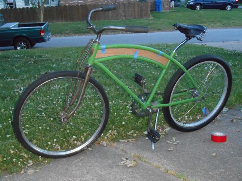 Green cruiser bicycle parked on sidewalk