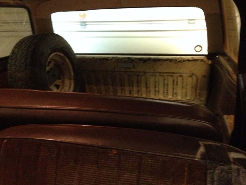 Interior of a vehicle showing a spare tire and brown seats.