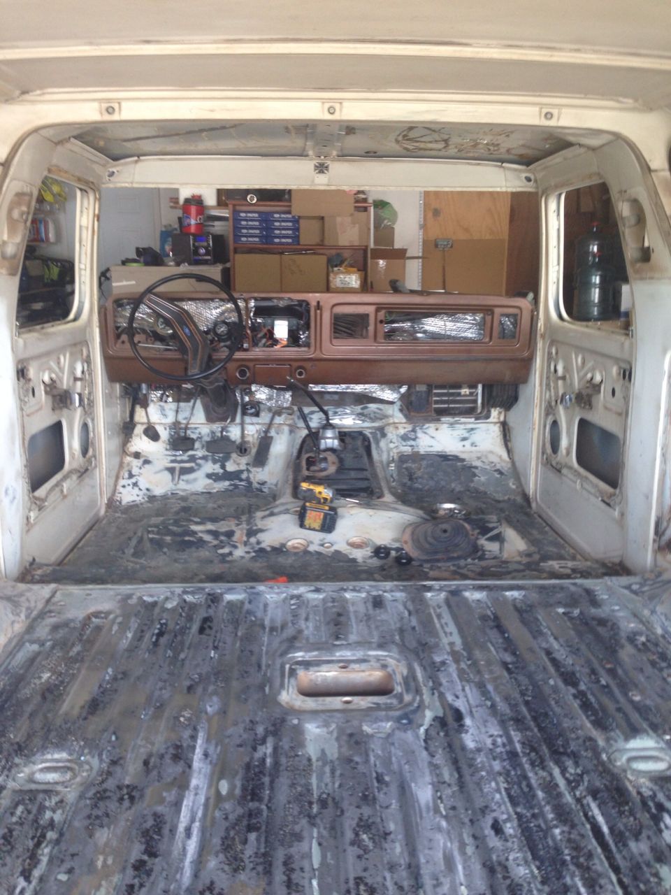 Interior view of a classic Ford Bronco undergoing restoration, looking forward.
