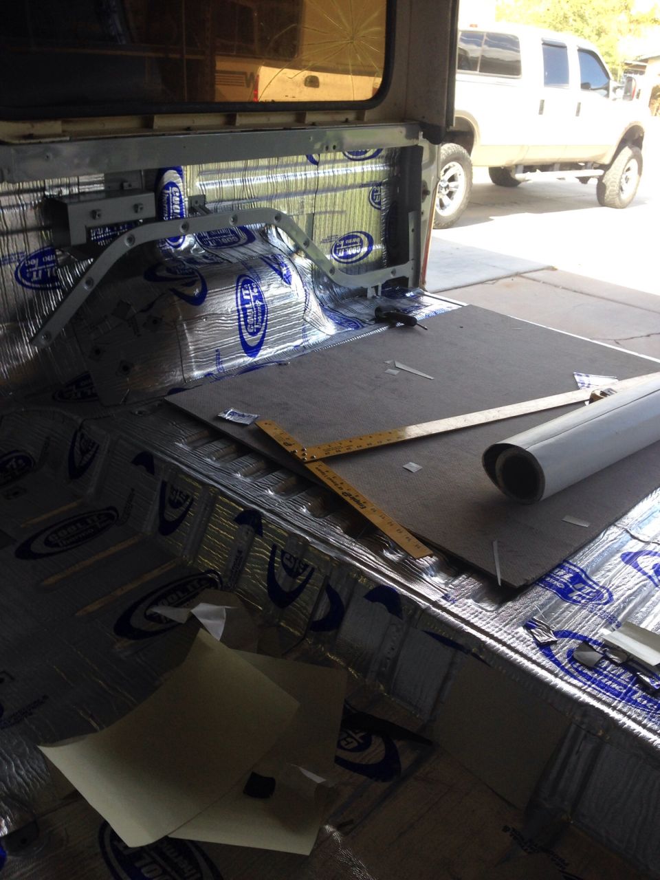 Interior of a vehicle with soundproofing material being installed.
