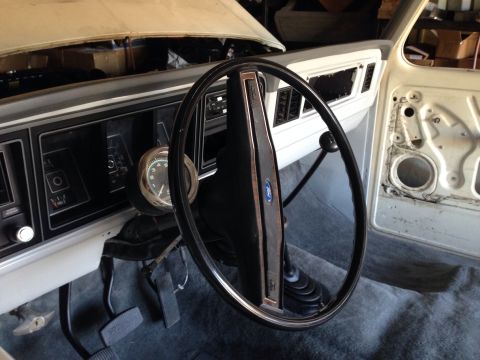1978 Ford Bronco - Interior view of a classic Ford truck or SUV, showing the dashboard, steering wheel, and pedals. The driver's side door panel is removed, r…