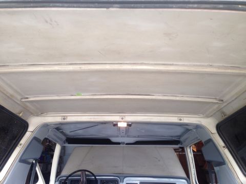1978 Ford Bronco - Interior view of a classic vehicle's headliner and upper door frames, showing exposed metal and some surface preparation for painting.