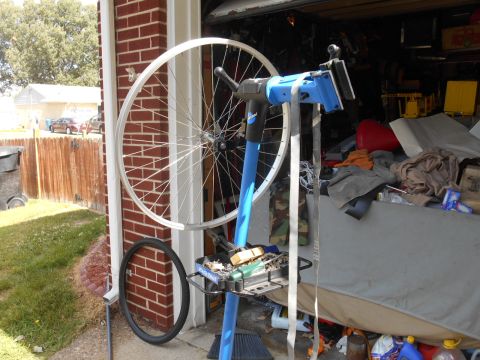 Bicycle wheel on repair stand with tire on ground