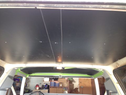 1978 Ford Bronco - The interior of a vehicle's headliner is being worked on, with black material installed and green masking tape around the edges. The view i…
