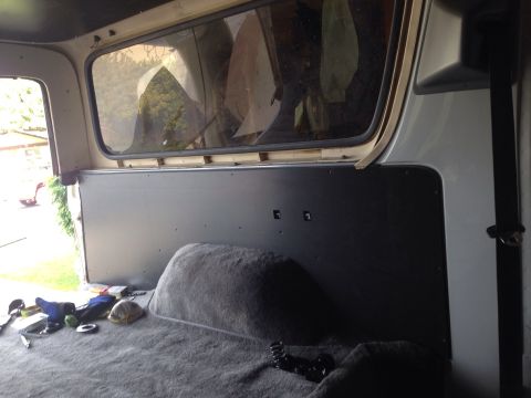1978 Ford Bronco - The interior of a vehicle, likely a Ford Bronco, shows the rear cargo area with a gray carpeted floor and a dark panel on the back wall. Va…