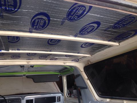 1978 Ford Bronco - The interior ceiling of a vehicle is being insulated with a silver material featuring blue "COOL IT thermo tec" logos. The vehicle appears…