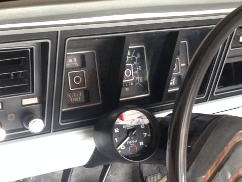1978 Ford Bronco - The interior of a vintage Ford Bronco shows the dashboard with various gauges including oil pressure, fuel level, and a tachometer. A porti…