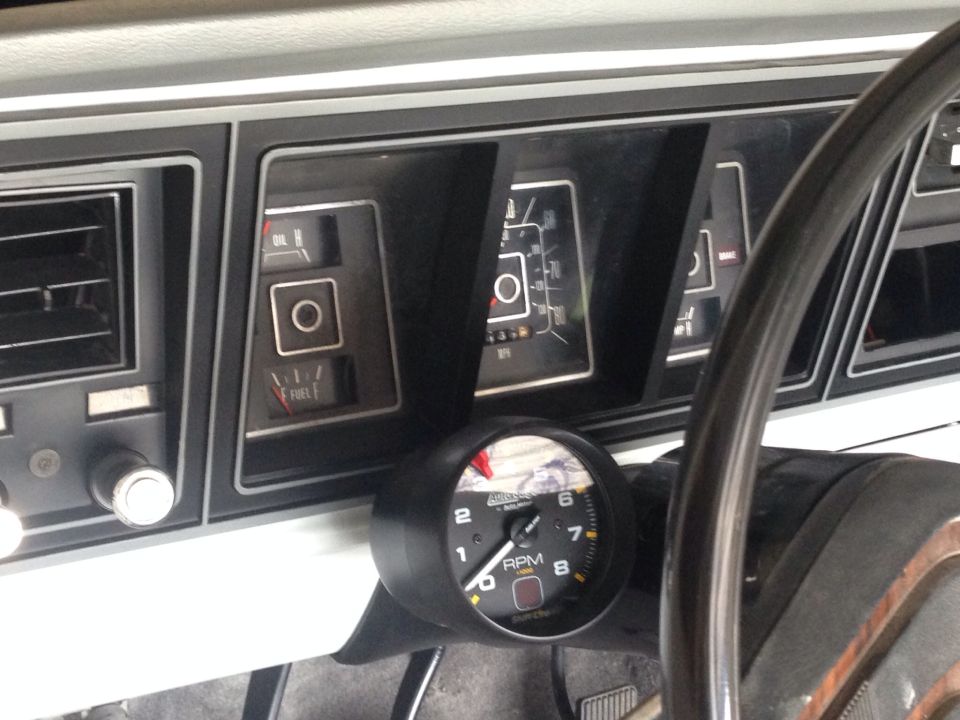 Vintage Ford Bronco dashboard with gauges and steering wheel.