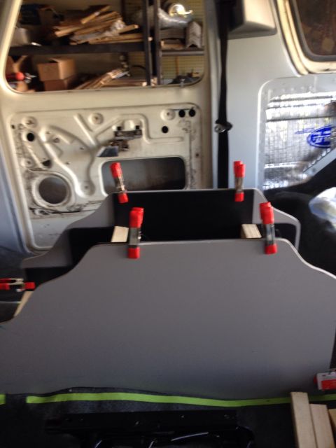 1978 Ford Bronco - A gray custom-shaped panel is being held in place with red spring clamps inside what appears to be the interior of a vehicle. The panel has…