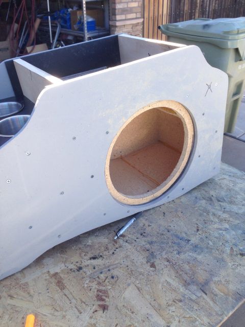 1978 Ford Bronco - A custom-built speaker enclosure with a large circular cutout for a speaker is shown resting on a plywood surface. The enclosure is painted…