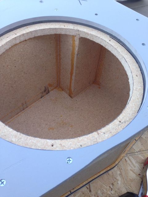 1978 Ford Bronco - The interior of a speaker enclosure is shown, constructed from particle board and sealed with orange adhesive. The enclosure is mounted wit…