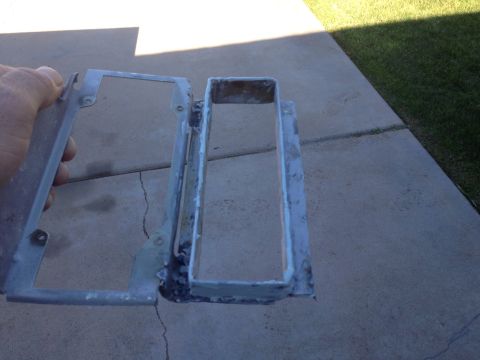 1978 Ford Bronco - A person's hand holds a metal bracket with a rectangular opening, attached to a larger, welded metal frame. The items are resting on a conc…
