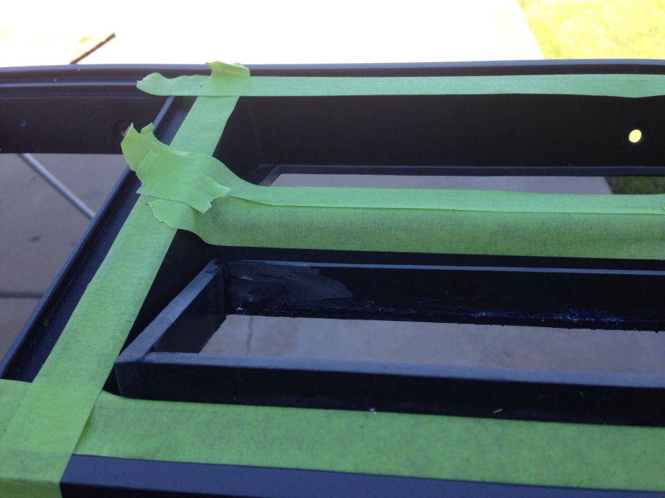Black metal frame with green painter's tape applied.