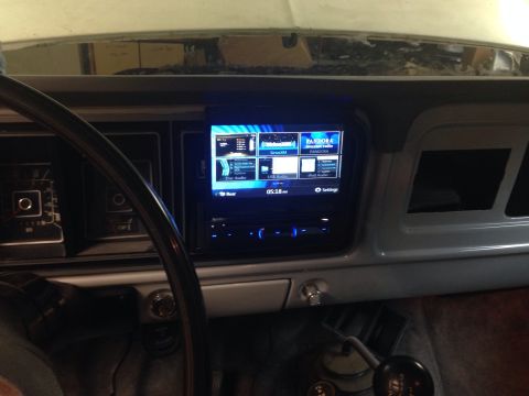 1978 Ford Bronco - The interior of a classic Ford Bronco shows a modern touchscreen head unit installed in the dashboard, replacing the original radio. The st…