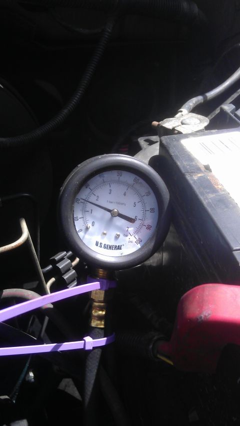 1994 Ford Bronco - A close-up view of a U.S. General pressure gauge connected to a hose with purple zip ties. The gauge is measuring pressure in psi and bar,…