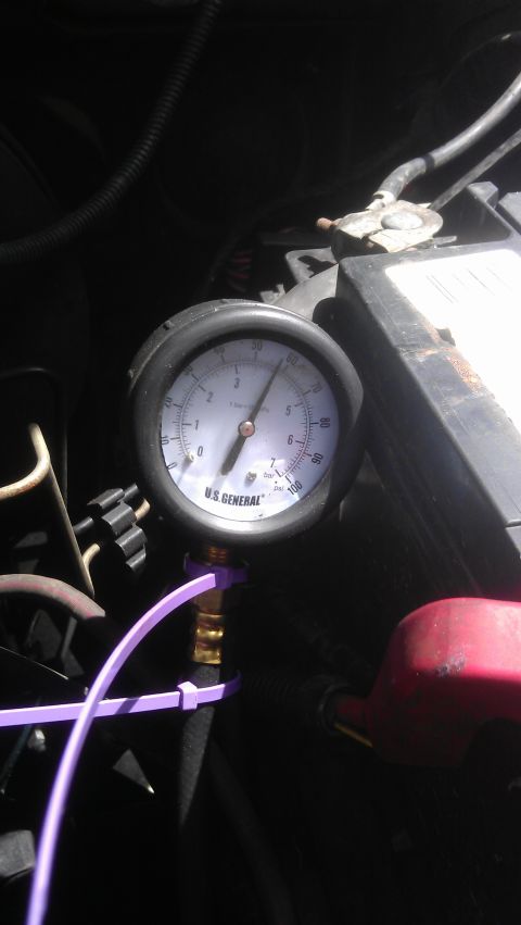 1994 Ford Bronco - A close-up view of a U.S. General pressure gauge connected to an engine component with a purple zip tie. The gauge shows a reading between…