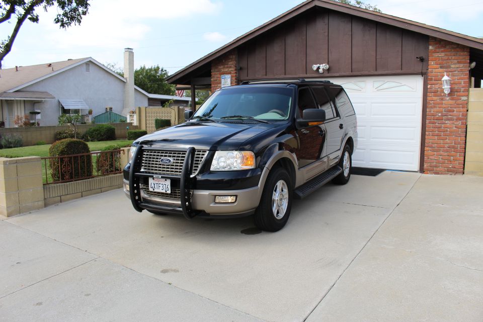 Black 2003 Ford Expedition SUV with brush guard parked in driveway.
