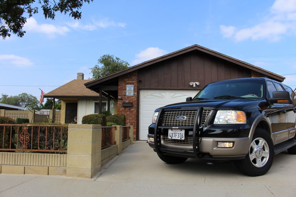Black Ford Expedition with brush guard parked in driveway of a house.