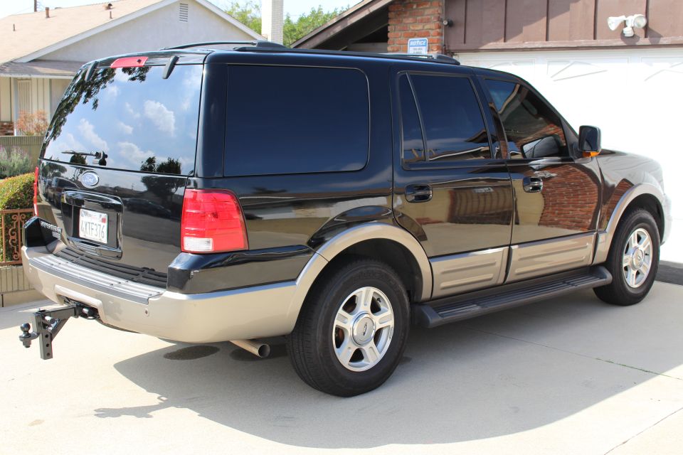 Dark blue 2003 Ford Expedition SUV, rear quarter view, chrome wheels, tow hitch