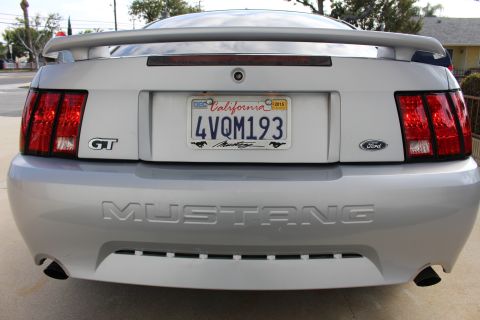 2002 Ford Mustang - The rear view of a silver 2002 Ford Mustang GT shows its taillights, California license plate reading "4VQM193", and the "MUSTANG" text emb…