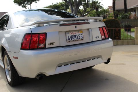 2002 Ford Mustang - The rear view of a silver Ford Mustang GT shows its taillights, spoiler, and California license plate.