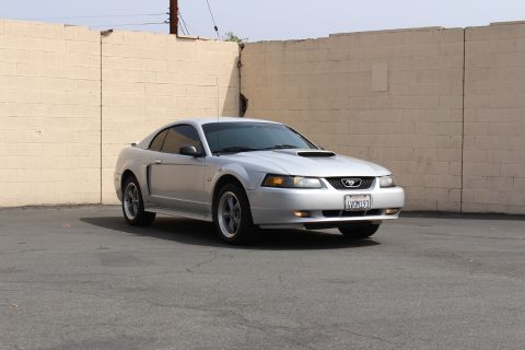2002 Ford Mustang - This silver 2002 Ford Mustang coupe is shown from a three-quarter front view, a distinctive hood scoop and a California license plate.