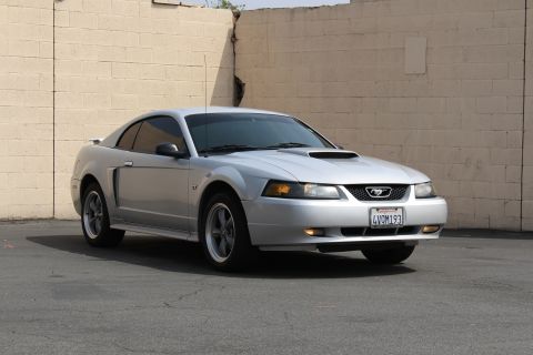 2002 Ford Mustang - Silver 2002 Ford Mustang GT with a hood scoop and GT badging.