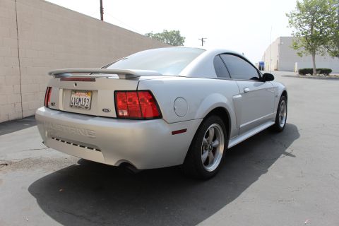 2002 Ford Mustang - Rear view of a silver 2002 Ford Mustang coupe parked on asphalt.