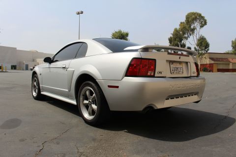 2002 Ford Mustang - Rear view of a silver 2002 Ford Mustang GT coupe with a spoiler and GT badge.