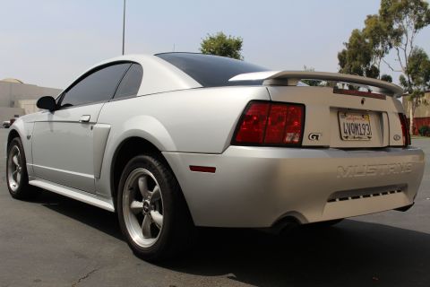 2002 Ford Mustang - Rear view of a silver Ford Mustang GT with a spoiler and custom license plate.