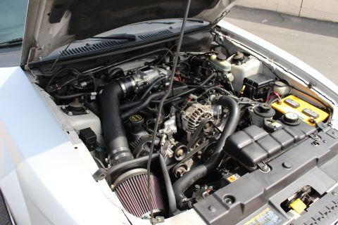 2002 Ford Mustang - Engine bay of a 2002 Ford Mustang, showing the V8 engine and various components.