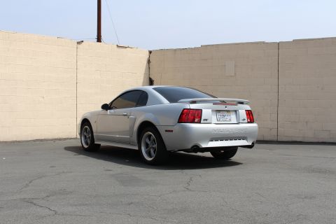 2002 Ford Mustang - Rear view of a silver 2002 Ford Mustang coupe with a spoiler and aftermarket wheels.