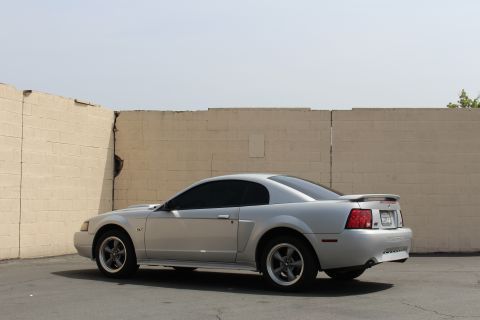 2002 Ford Mustang - Rear three-quarter view of a silver 2002 Ford Mustang coupe with a spoiler.